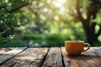 Yellow coffee cup on rustic wooden table against blurred green garden background with beautiful bokeh lights, perfect for lifestyle and relaxation concepts.
