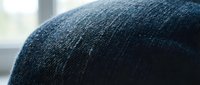 Macro close-up of dark blue textured fabric surface showing woven fibers and material detail for textile, fashion, and design projects.