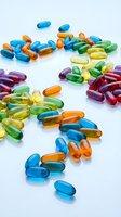 Colorful vitamin capsules and supplements scattered on white background for healthcare and wellness concepts.