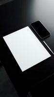 Minimalist workspace with blank white paper, smartphone and pen on dark surface for business planning and creative projects.