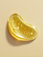 Golden honey drop with air bubbles on beige background, curved organic shape with transparent glossy texture and sparkling effect for cosmetic packaging design.