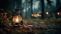 Vintage oil lantern glowing warmly on forest ground with blurred lights creating magical camping atmosphere in dark woodland setting.