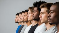 Diverse group of young men standing in profile line showing multicultural teamwork and unity in modern workplace or educational setting.