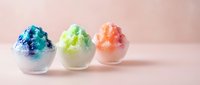 Colorful shaved ice cups with blue, green, and orange flavored toppings on pink background. Refreshing summer dessert for beverage, food, and confectionery design use.