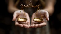 Female hands holding golden scales of justice against dark background, symbolizing law, balance, and fairness in legal system and decision making process.