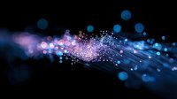 Glowing fiber optic network with pink and blue bokeh lights flowing through dark background creates futuristic technology visualization effect.