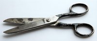 Vintage metal scissors with worn patina finish and black handles, suitable for crafting, sewing, tailoring, and antique collection displays.