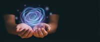 Hands holding glowing purple energy spiral with light particles floating above palms against dark background for technology and innovation concepts.