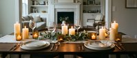 Elegant dining table set with lit candles, wine glasses, and greenery garland for formal dinner party or holiday celebration entertaining.
