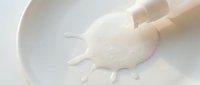 Pouring milk into white bowl, dairy product splash and flow, cooking and baking ingredient for recipes and food preparation.