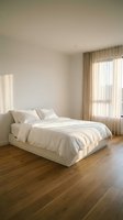 Minimalist bedroom interior with white platform bed, neutral bedding, wooden floors, and natural light filtering through beige curtains creating serene atmosphere.