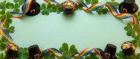 Leprechaun hats, gold coins, and shamrock leaves arranged on mint green background with rainbow ribbons, ideal for St. Patrick's Day celebrations and holiday designs.