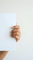 Hand holding blank white card against neutral background, suitable for advertising, marketing campaigns, and promotional messaging.
