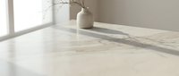 Minimalist interior with marble table surface, ceramic vase with dried branches, soft natural lighting creating elegant shadows for modern home decor.