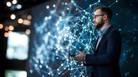 Caucasian businessman with glasses and beard looking at digital network visualization while holding smartphone in dark room with glowing connections.