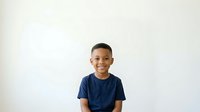 Young boy, approximately 8-10 years old, with dark hair and medium brown skin tone, wearing a navy blue t-shirt, smiling at camera against white background. Isolated portrait suitable for educational materials, family content, and design projects.
