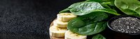 Fresh banana slices with raw spinach leaves and chia seeds on dark background, healthy breakfast ingredients for smoothie bowl or detox drink.