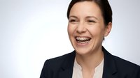 Happy professional businesswoman laughing with dental braces in corporate attire against white background for business presentations.