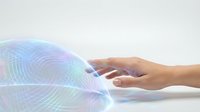 Human hand reaching toward holographic fingerprint scanner with colorful digital biometric authentication technology for security and identity verification.