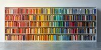 Rainbow-colored books arranged by spectrum on white bookshelf in modern interior, creating vibrant gradient display for library or bookstore design.