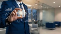 Businessman in blue suit holding glowing cube with financial icons and data analytics symbols in modern office environment for business technology concepts.