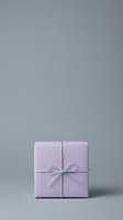 Lavender gift box with white ribbon bow on neutral gray background, suitable for holiday, birthday, and celebration marketing materials.