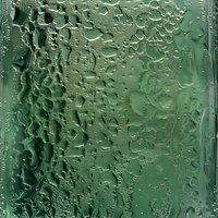 Water drops and condensation on green glass surface creating abstract natural pattern with light refraction and textured background for creative designs.