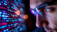 Young male programmer reflected in computer screen with glowing code and data visualization, dramatic lighting highlights focused expression and glasses.