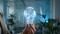 Professional businesswoman holding glowing lightbulb with network connections in modern office environment representing innovation and creative solutions.