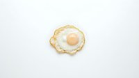 Fried egg with golden crispy edges and runny yolk on white background, isolated breakfast food ready for cooking and culinary design projects.