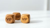 Three wooden dice with VIP text engraved on faces, premium service concept for luxury business marketing and exclusive membership programs.