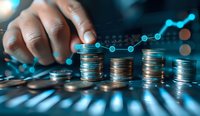 Male hand stacking coins with rising digital graph overlay in blue tones, representing financial growth, investment success and business analytics concept.