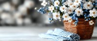 Spring flower arrangement with white daisies and blue forget-me-nots in wicker basket on wooden table with checkered napkin for home decor and seasonal styling.