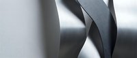 Abstract metallic ribbons with flowing curves and reflective surfaces creating dynamic sculptural forms against soft gradient background.