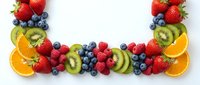 Fresh mixed berries and fruits arranged in decorative border on white background. Colorful healthy eating concept with strawberries, blueberries, kiwi, oranges.