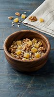 Wooden bowl filled with mixed nuts, seeds and dried fruit on rustic blue table with linen napkin for healthy snacking and breakfast preparation.