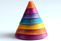 Colorful striped cone shape with glittery rainbow layers stacked in vibrant orange, pink, purple, turquoise and yellow hues against white background, isolated decorative element.
