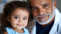 Heartwarming portrait of mixed race family bonding moment between smiling senior man with gray beard and adorable curly-haired little girl in blue shirt.