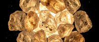 Scattered golden brown roasted chickpeas on black background, overhead view for food photography, snacking, nutrition, and healthy eating content.