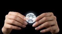 Hands holding glowing crystal sphere against dark background, representing innovation, future technology, and business solutions for corporate and creative projects.