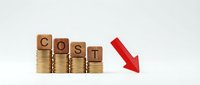 Wooden blocks spelling COST on stacks of coins with red arrow pointing down, representing expense reduction and financial savings concept.