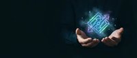 Hands holding glowing neon circuit board symbol with digital particles on dark background, representing technology innovation and digital transformation for business solutions.
