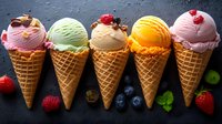 Colorful ice cream scoops in waffle cones arranged in row with fresh berries and mint leaves on dark background. Variety of flavors including strawberry, pistachio, vanilla.