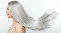 Woman with long, flowing silver hair in profile against white background, showcasing hair care, beauty, and aging gracefully for cosmetics and wellness.