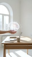 Hand holding glowing digital brain hologram above modern workspace with laptop and coffee cup in bright minimalist office interior for AI technology concepts.