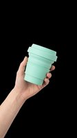 Caucasian hand holding mint green reusable coffee cup with lid isolated on transparent background, ready for t-shirt design, clipart, stickers, and print-on-demand products.