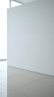 Minimalist white interior corner with clean walls and tiled floor in modern architectural space with natural light from windows.