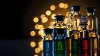Laboratory glass bottles with colorful chemical solutions and warm bokeh lights creating scientific research atmosphere for educational content.