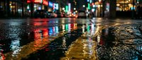 Wet city street at night with colorful neon lights reflecting on rain-soaked asphalt pavement creating vibrant urban atmosphere for nightlife and metropolitan concepts.