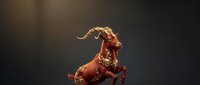 Majestic bronze goat sculpture with ornate decorative details rearing up on hind legs against dramatic dark background with warm golden lighting.